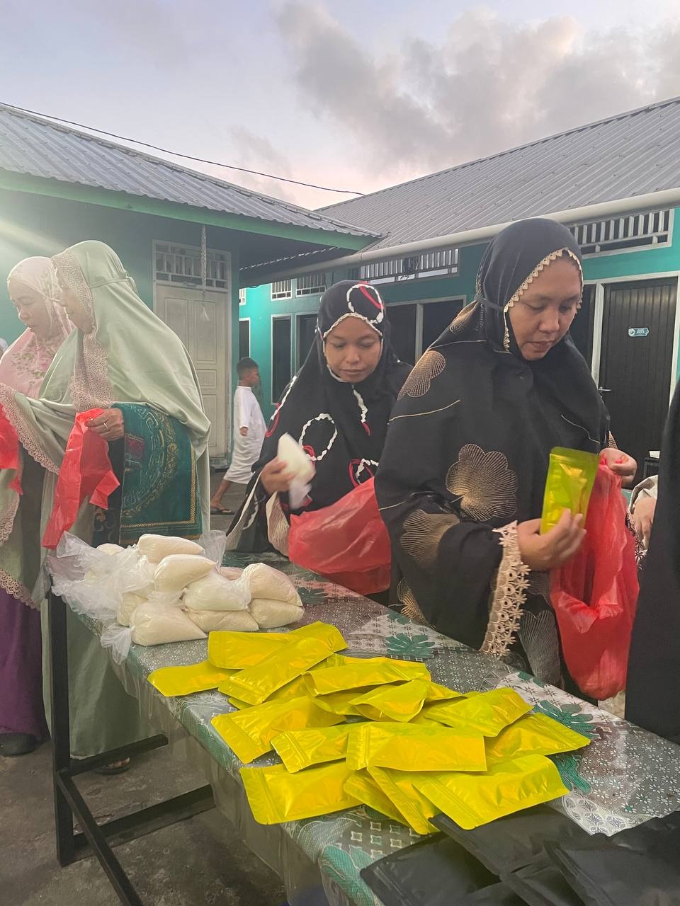 Para jamaah memasukkan satu persatu family support kedalam plastik