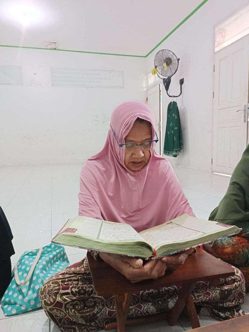 Sambil menunggu giliran lansia binaan almarhamah memperlancar bacaannya sendiri