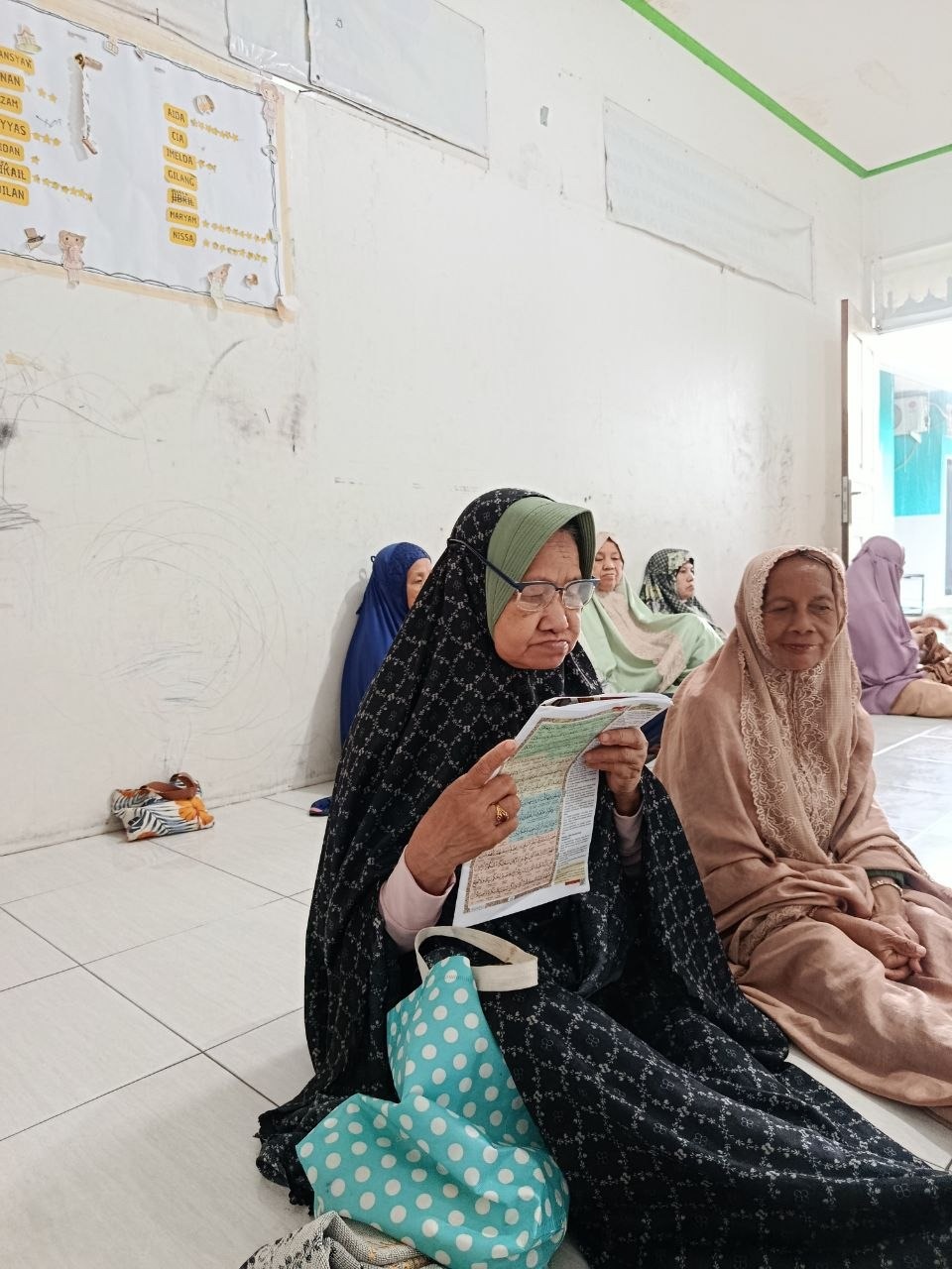 Lansia Almarhamah Fokus Membaca Al Qur'an