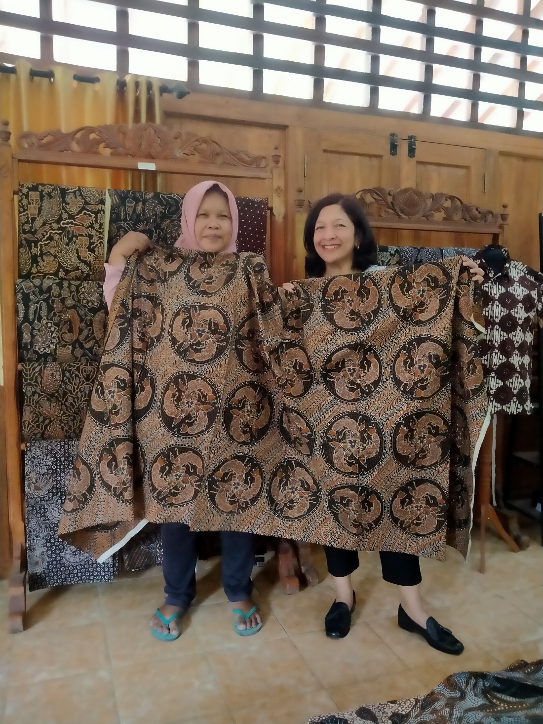 Ibu Siti bertemu langsung dengan pembeli batiknya, seorang wisatawan di Kampung Batik Giriloyo