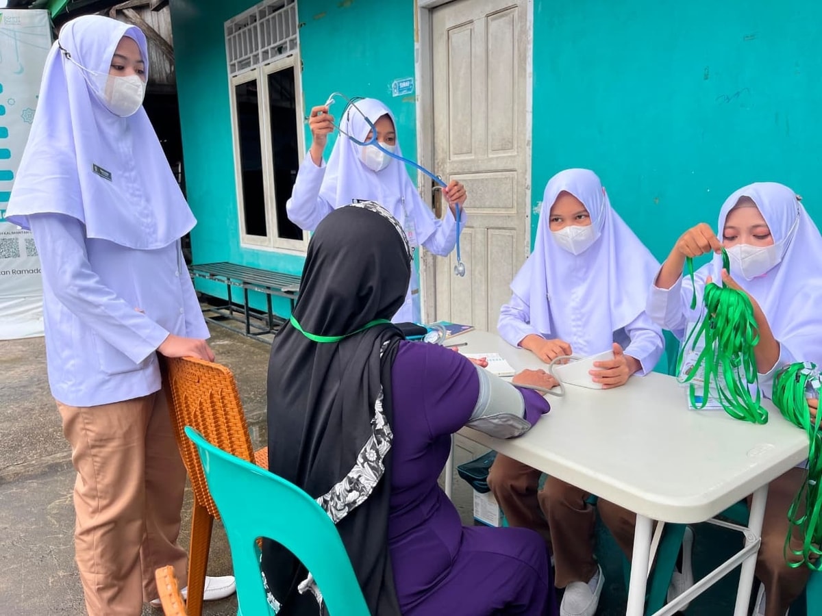 Para Siswi SMK Kesehatan Kaltara memeriksa tekanan darah pada lansia peserta sekolah lansia