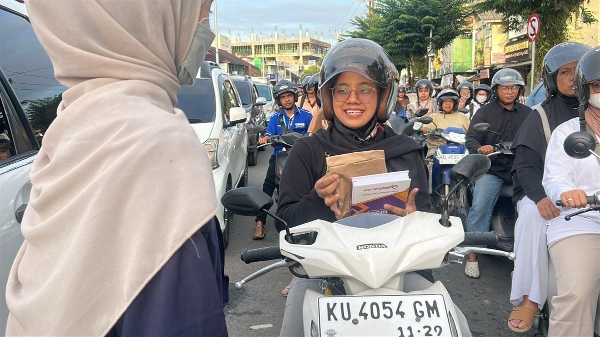 Salah satu mahasiswa memberikan takjil kepada pemotor di lampu merah THM