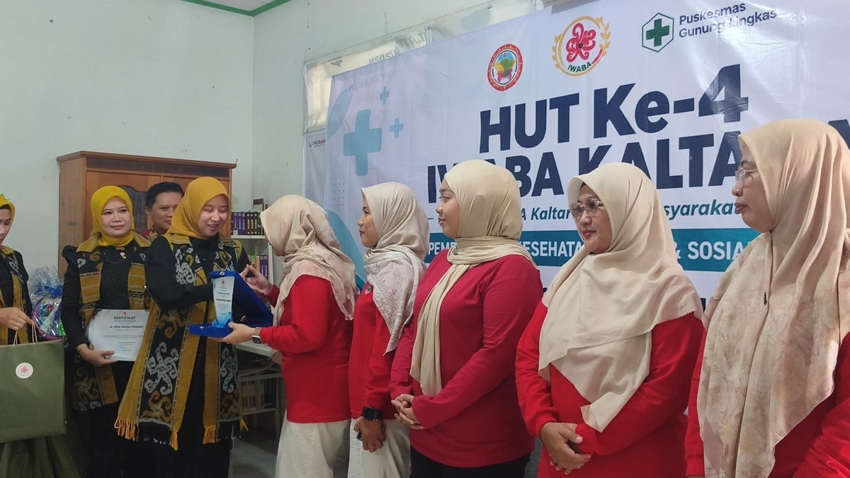 Penyerahan plakat dan sertifikat kepada tenaga kesehatan dari Puskesmas Gunung Lingkas