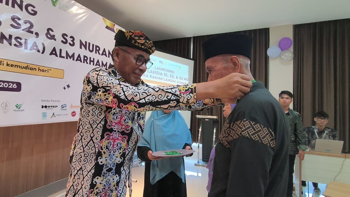 pengalungan simbolis oleh Kepala Dinas Sosial kepada perwakilan peserta sekolah lansia NURANI