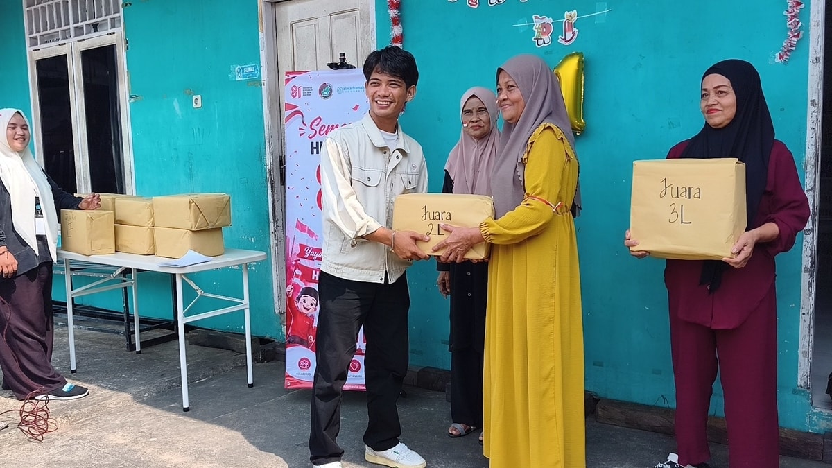 Bang Aswan, Ketua HIMBA BK UBT meberikan hadiah untuk lansia pemenang lomba