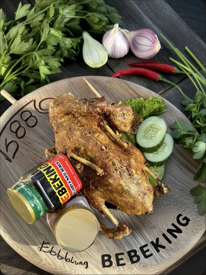 Bebek goreng utuh renyah disajikan di talenan kayu