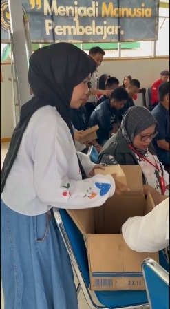 Pembagian nasi berkah oleh panitia