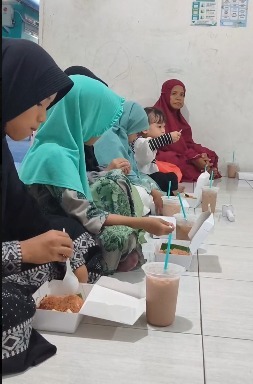 Santri menyantap nasi berkah setelah berdoa