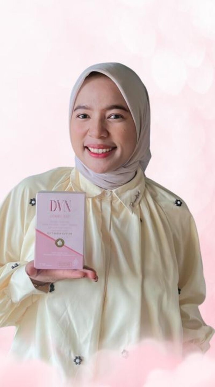 Manda, admin resmi D.V.N, memegang kemasan D.V.N Chewable Tablet