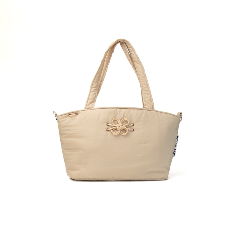 Blume Tote Bag beige dari Into The Lume dengan hiasan tali berbentuk bunga di bagian depan, totebag stylish dan ringan untuk aktivitas sehari-hari.