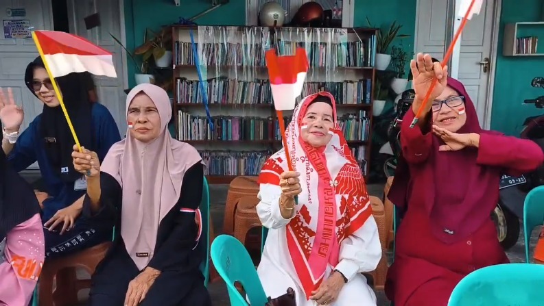 Lansia mengayunkan bendera yang diberikan